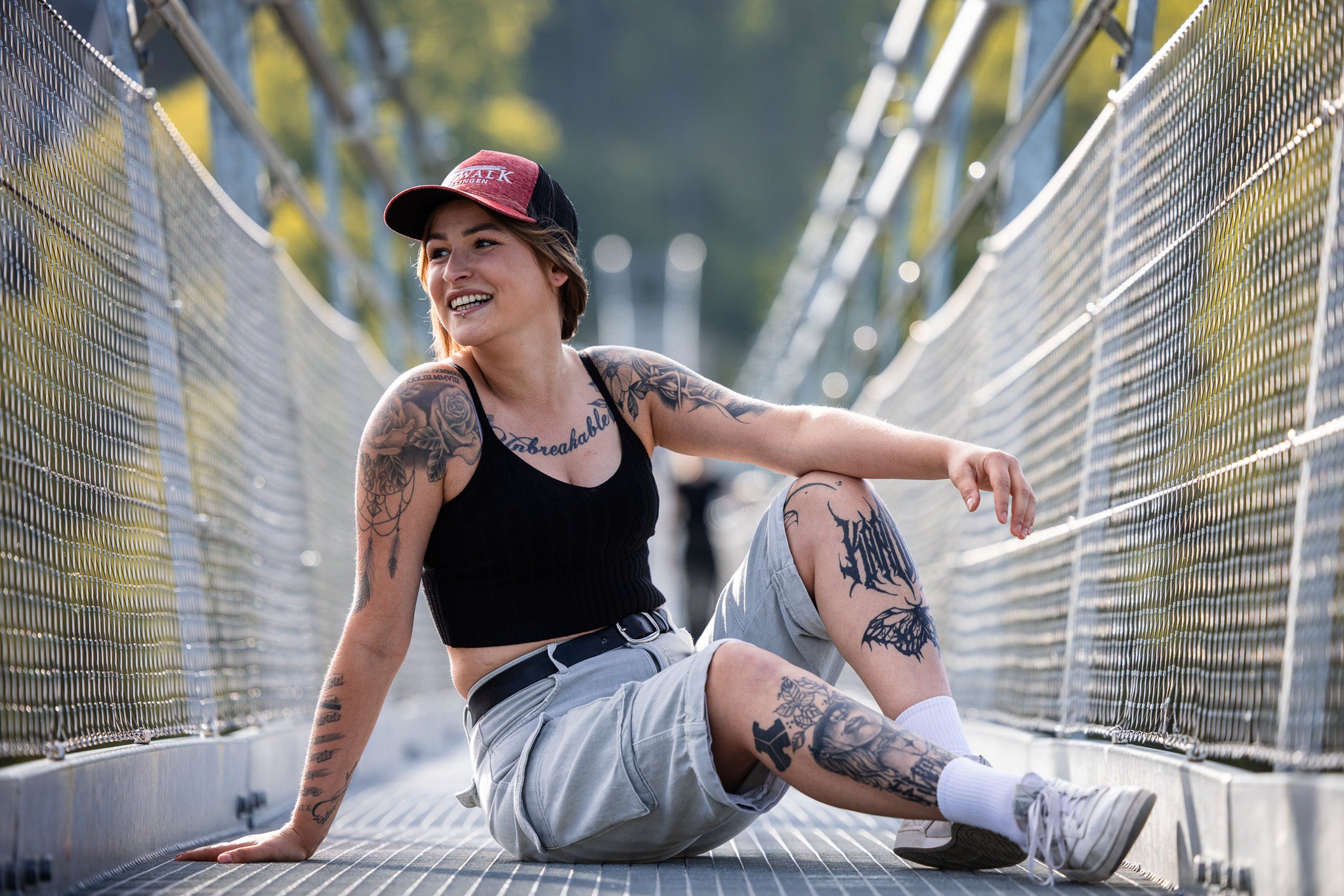Bild: Es zeigt die Kappe an einer jungen Frau, die auf der Brücke sitzt.