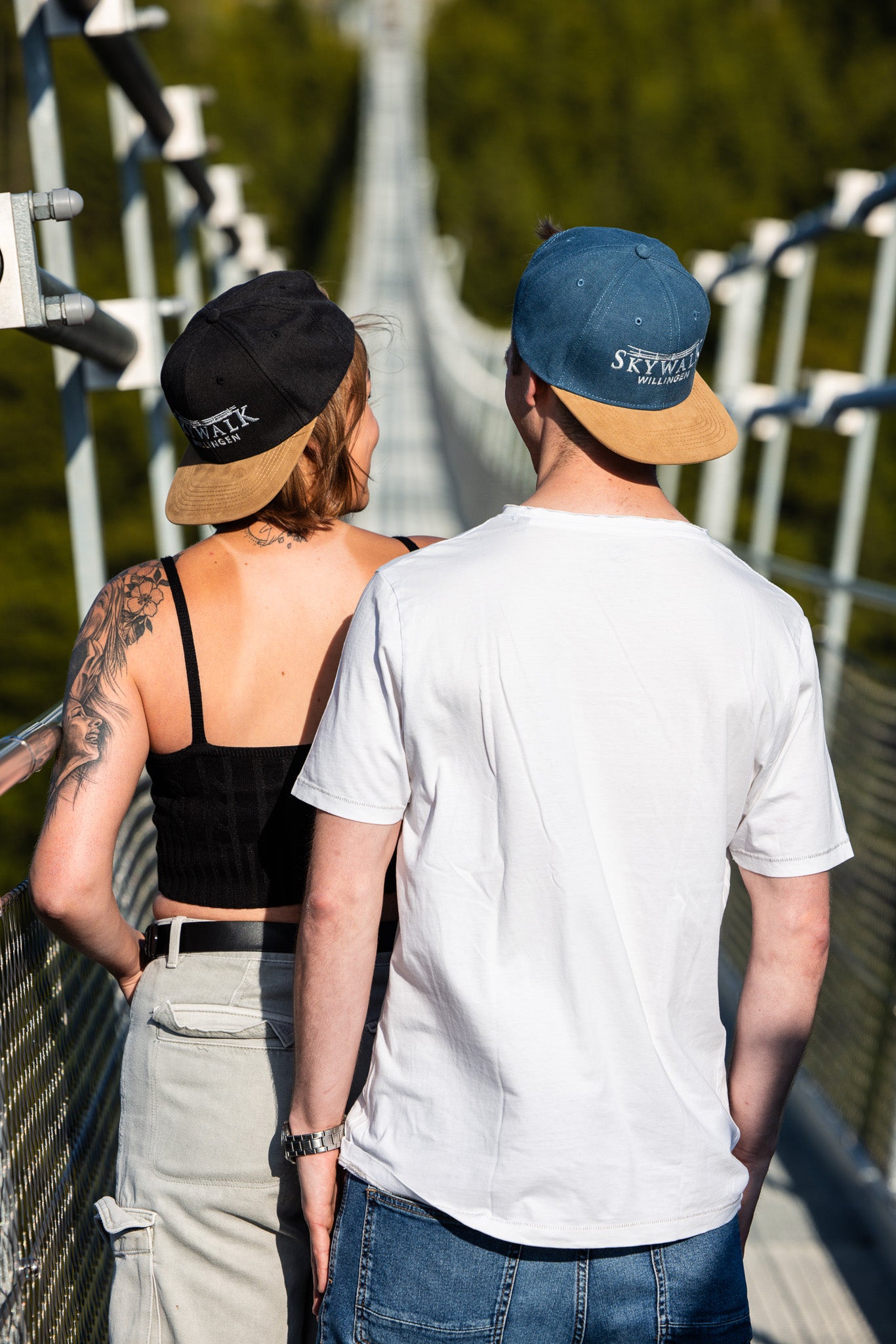 Bild: Es zeigt zwei junge Menschen auf der Brücke, die die Kappen backward tragen.