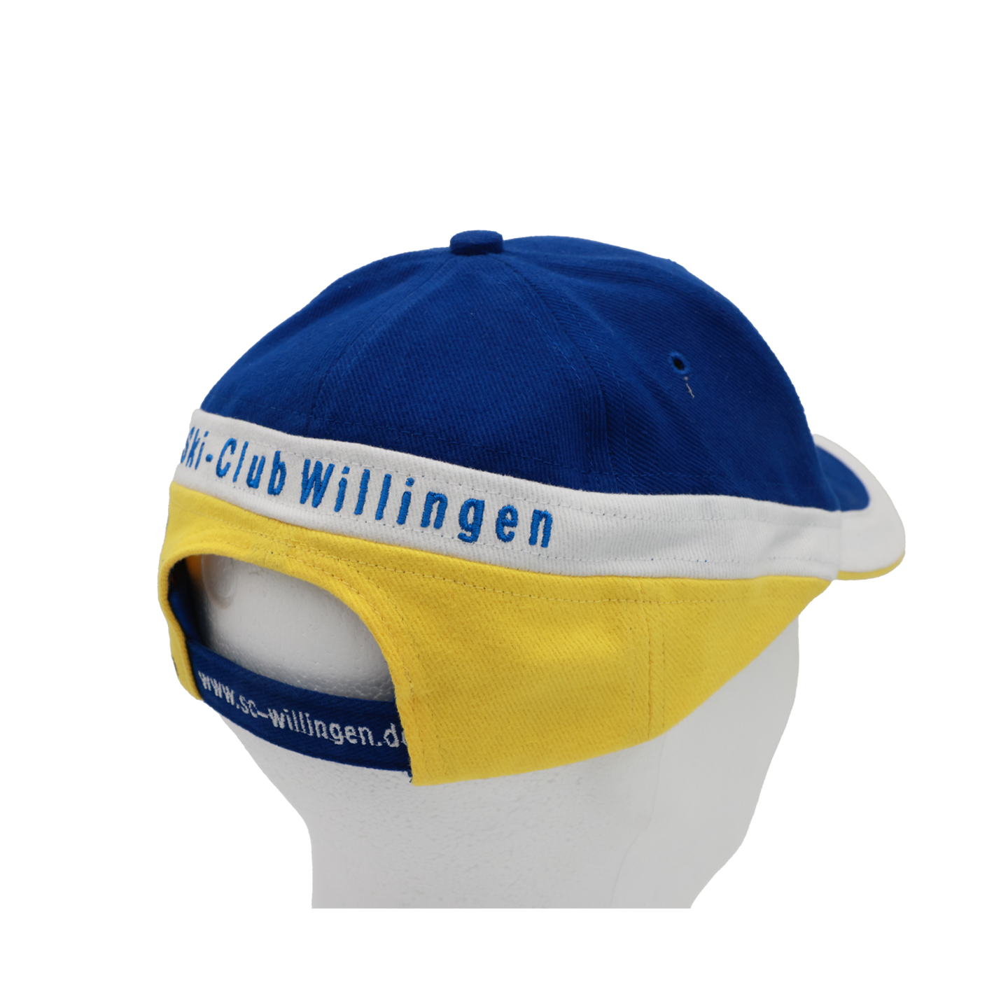 Bild: Kappe vom Ski-Club Willingen seitlich von hinten rechts. Mittig im weißen schräg angebrachten Teil ist in blau "Ski-Club Willingen" eingestickt. Darunter folgt ein gelber schräger Teil.
